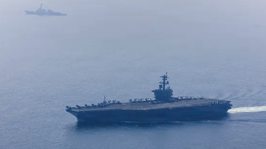 The US Navy's aircraft carrier USS Abraham Lincoln and guided-missile destroyer USS Frank E Petersen Jr sail in the Arabian Sea