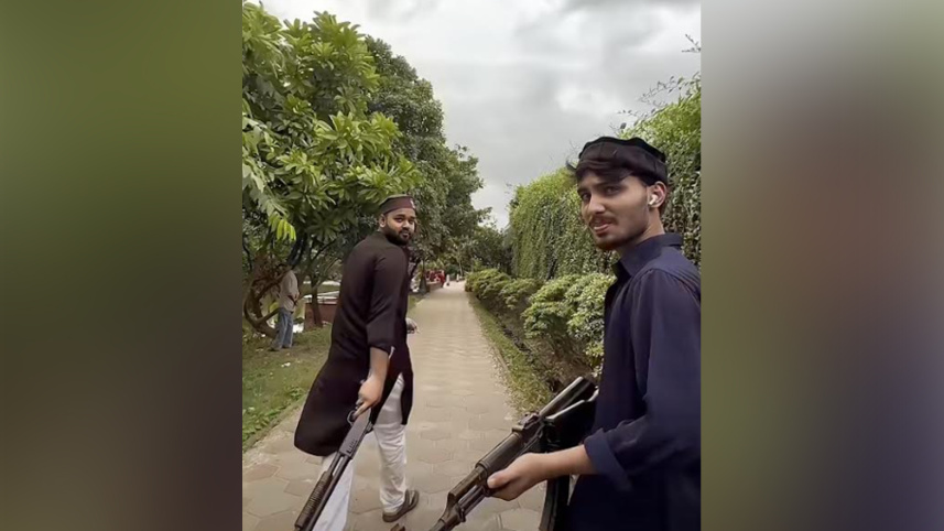 খেলনা বন্দুক হাতে লিমন তোহা ও স্বপন মোল্লা। ছবি: ভিডিও থেকে নেওয়া