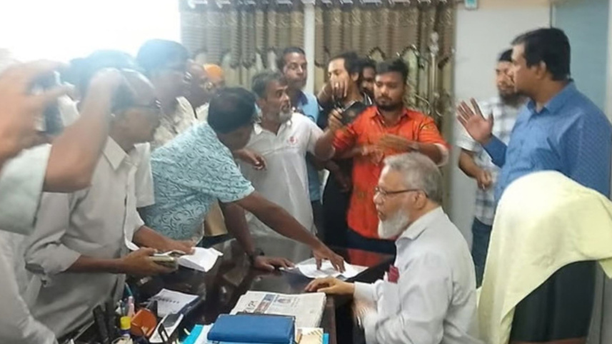 রাজশাহী মেডিকেল বিশ্ববিদ্যালয়ের উপাচার্য অধ্যাপক জাওয়াদুল হককে কার্যালয়ে হেনস্তা করে একদল লোক। ছবি: সংগৃহীত