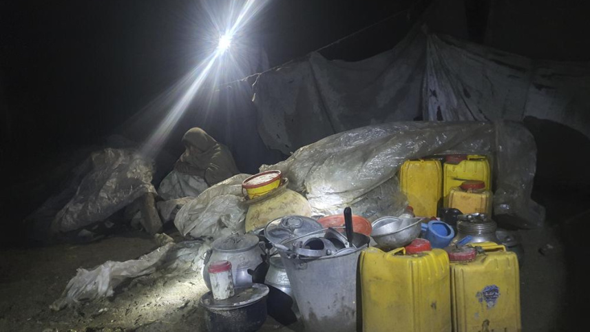 গায়ান গ্রামে ধংসযজ্ঞের মাঝে সাময়িক আশ্রয় খুঁজছেন এক আফগান নারী। ছবি: এপি