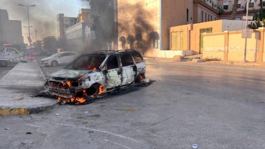 শনিবারের সংঘর্ষে ত্রিপোলির সড়কে গাড়িতে আগুন জ্বলছে। ছবি: রয়টার্স