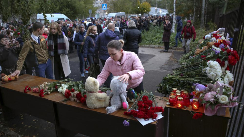 স্কুলের সামনে নিহত শিশুদের স্মৃতিচারণের জন্য খেলনা ও ফুল অর্পন করছেন অভিভাবকরা। ছবি: এপি
