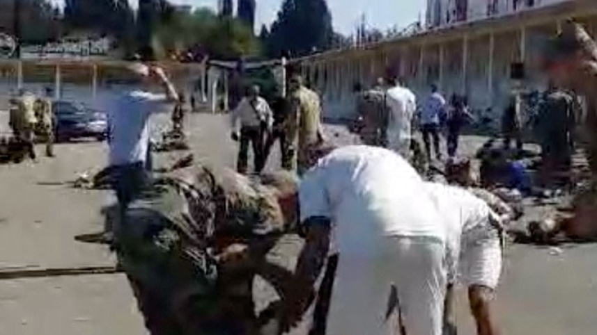 সিরিয়ার সামরিক একাডেমিতে ড্রোন হামলার পর এক আহত ব্যক্তিকে অন্যরা সাহায্য করছেন। ছবি: রয়টার্স