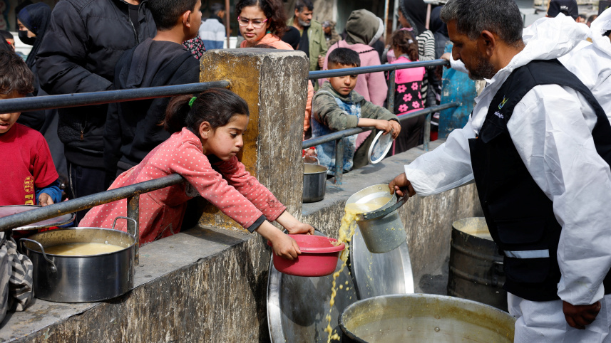 দক্ষিণ গাজার রাফাহ শহরে বাস্তুচ্যুত ফিলিস্তিনি শিশুরা  একটি দাতব্য লঙ্গরখানা থেকে খাবার সংগ্রহ করছে। ফাইল ছবি: রয়টার্স 