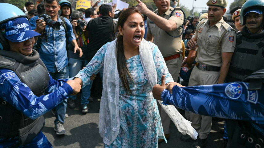 কেজরিওয়ালের মুক্তির দাবিতে বিক্ষোভরত আম আদমি সমর্থককে গ্রেপ্তার করছে পুলিশ। ছবি: এএফপি