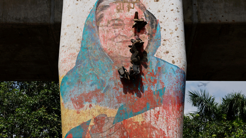 শেখ হাসিনার পতনের পর তার ম্যুরাল বিকৃত করে বিক্ষোভকারীরা। ছবি: রয়টার্স