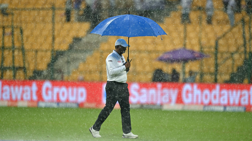 an_umpire_walks_across_the_ground_as_it_rains.jpg