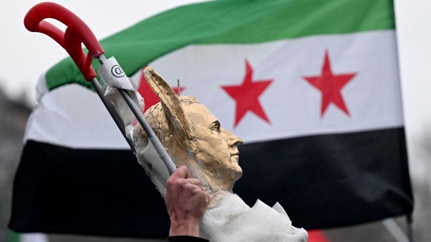 ছাগলের কান সম্বলিত বাশারের প্রতিকৃতি নিয়ে আনন্দ মিছিল করছে প্রবাসী সিরিয়রা। ছবি: এএফপি