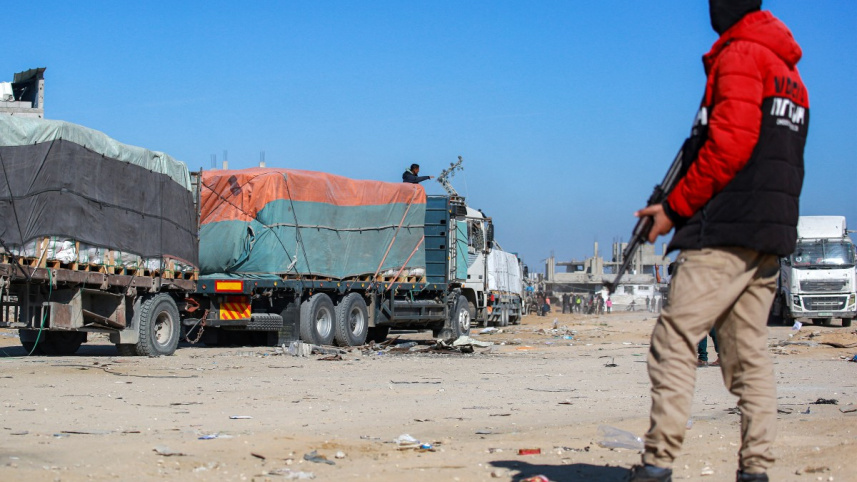 গাজায় ত্রাণবাহী ট্রাক প্রবেশের সময় প্রহরা দিচ্ছেন এক হামাসপন্থি নিরাপত্তা কর্মী। ছবি: এএফপি
