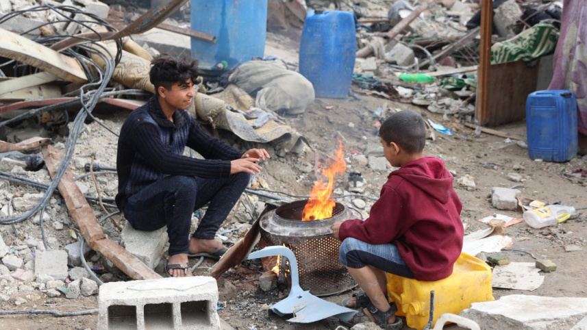 উত্তর গাজার জাবালিয়ায় আগুন পোহাচ্ছে ফিলিস্তিনিরা। ছবি: এএফপি