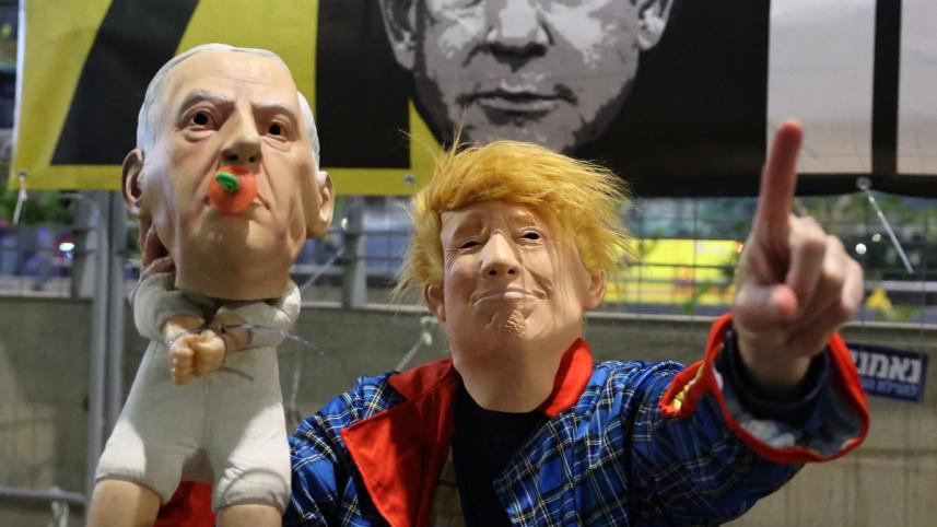 তেল আবিবে নেতানিয়াহুর বিরুদ্ধে বিক্ষোভ জানাতে এক ইসরায়েলি ট্রাম্পের বেশ ধারণ করেন। তার হাতে নেন নেতানিয়াহুর পুতুল। ছবি: এএফপি