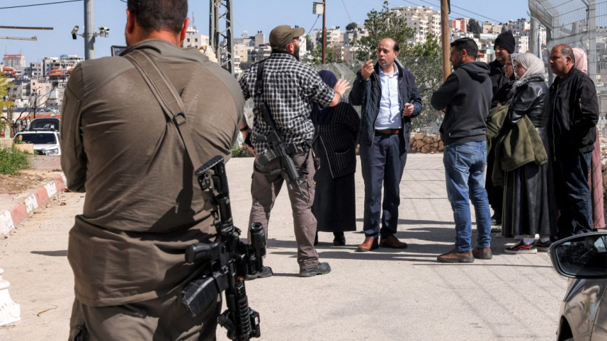 নিজ বাড়ি থেকে বিতাড়িত হয়ে সশস্ত্র ইহুদি অবৈধ বসতকারীর সঙ্গে তর্কে জড়িয়েছে এক ফিলিস্তিনি পরিবার। ফাইল ছবি: এএফপি