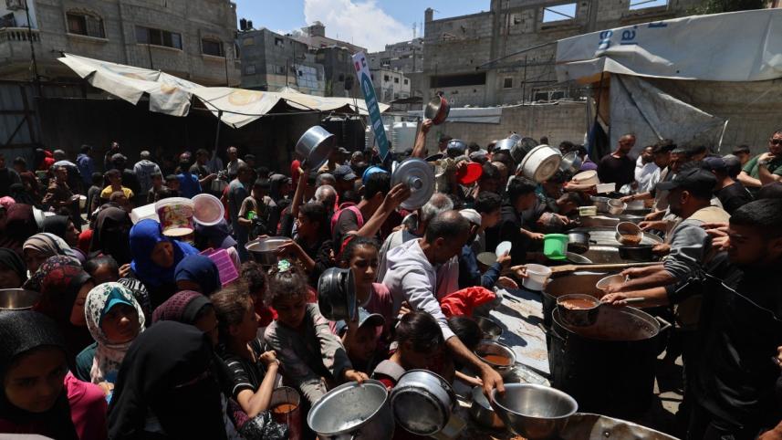 গাজার নুসেইরাতের আশ্রয় শিবিরে গরম খাবারের অপেক্ষায় ফিলিস্তিনিরা। ছবি: এএফপি