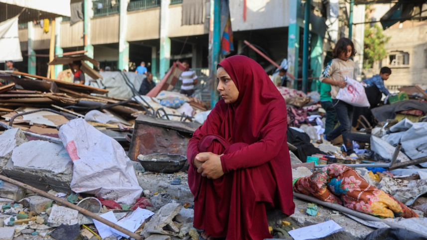 ধ্বংসযজ্ঞের মাঝে এক ফিলিস্তিনি নারী শূন্য দৃষ্টিতে তাকিয়ে আছেন। ছবি: এএফপি