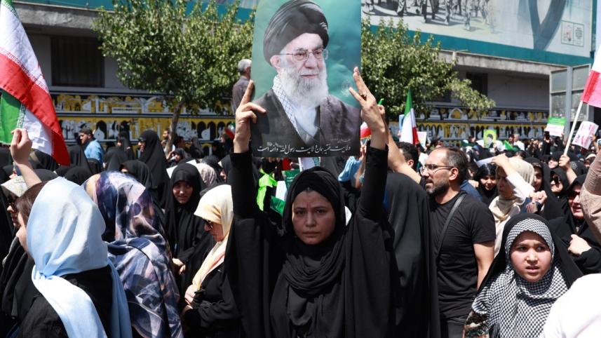 খামেনির ছবি হাতে এক ইরানি নারী। ছবি: এএফপি