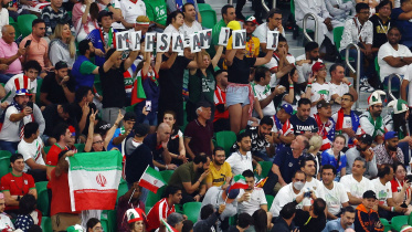 দ্বিতীয়ার্ধের শুরুতে কিছুটা সময় কয়েকজন দর্শক মাহসা আমিনির নাম লেখা ব্যানার তুলে ধরেন। ছবি: রয়টার্স