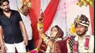 বিয়ের আসরে বসে গুলি ছুঁড়ে উদযাপন করছেন কনে। ছবি: ভিডিও থেকে নেওয়া স্ক্রিণশট
