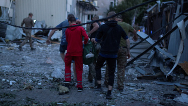 রেস্তোরাঁর ধ্বংসস্তুপ থেকে এক আহত ব্যক্তিকে বহন করে নিয়ে যাচ্ছেন স্বেচ্ছাসেবীরা। ছবি: রয়টার্স