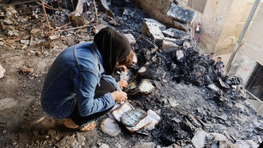 পশ্চিম তীরের জেনিন শরণার্থীশিবিরে ইসরায়েলি হামলার পর পুড়ে যাওয়া জিনিসের মাঝে সহায়সম্বল খুঁজে ফিরছেন এক ফিলিস্তিনি। ছবি: রয়টার্স