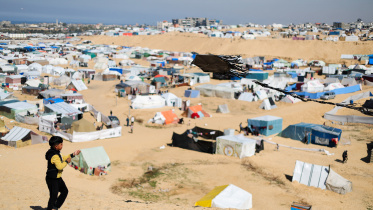 রাফাহ শহরে তাঁবুর নিচে বসবাস করছেন গাজার বিভিন্ন অংশ থেকে আসা বাস্তুচ্যুত ফিলিস্তিনিরা। এর মাঝে এক শিশু ঘুড়ি উড়িয়ে অবসর যাপন করছে। ছবি: রয়টার্স