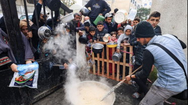 দক্ষিণ গাজার একটি দাতব্য লঙ্গরখানা থেকে খাবার সংগ্রহ করছে ফিলিস্তিনিরা। ছবি: এএফপি