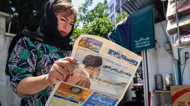 পত্রিকায় ইব্রাহিম রাইসির মৃত্যুসংবাদ পড়ছেন এক ইরানি নাগরিক। ছবি: ডয়চে ভেলে/এএফপি