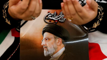 ইরানের প্রয়াত রাষ্ট্রপতি ইবরাহিম রাইসির বিদেহী আত্মার প্রতি সম্মান জানাচ্ছেন এক ইরানি। ছবি: রয়টার্স